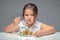 Girl at the table eating salad, overweight child.