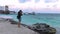 Girl take a picture on her camera on the beach at the Caribbean Sea in Cancun