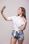 Girl take selfie on phone on grey background