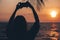 Girl takes a photo on the modern smartphone on the beach. .Silhouette of girl and palm tree on the sunset beach
