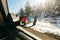 Girl takes pictures of herself through a car mirror. car rides through winter forest