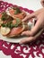 The girl takes the sandwich from the plate. Sandwiches with salmon, decorated with greens and lemon. Sandwiches on a plate, standi