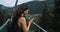 Girl taking a photo on the camera while rising up on the lift. Beautiful brunette travelling in Austria. Young woman