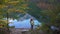 Girl taking a photo of mountain lake panorama