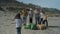 Girl taking photo to group of volunteers after cleaning beach