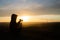 Girl taking photos during colored sunset in quarry Hady Brno with view inside city