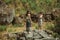 Girl taking picture of another girl among rocky landscape