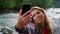 Girl taking selfie on mobile phone. Joyful woman making funny grimaces at camera
