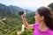 Girl taking smartphone picture of mountain nature