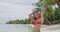 Girl taking smartphone selfie picture - travel woman in bikini on beach smiling