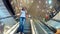 Girl talking on phone on escalator in a mall