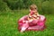 Girl talks by toy phone in inflatable armchair