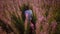 Girl in tall stems of blooming pink fireweed on at sunset.