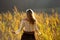 Girl with tattoo mountains on the shoulder standing and meditating in field of reeds / Blond girl walking through field of reeds