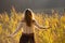 Girl with tattoo mountains on the shoulder standing and meditating in field of reeds / Blond girl walking through field of reeds