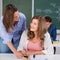 Girl And Teacher Looking At Each Other At Desk