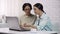 Girl teaching mother to use laptop, showing useful software, computer literacy