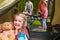 Girl With Teddy Bear Enjoying Camping Holiday On Campsite