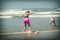 Girl or teen learning to ride a skimboard on the Oregon coast