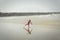 Girl or teen learning to ride a skimboard on the Oregon coast