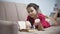 Girl teen reading a book lying on sofa indoors. girl kid reading a book lying indoors on a sofa