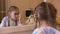 Girl teenager applying mascara on eyelashes front mirror in bedroom. Young girl using eyelashes mascara for makeup front