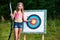 Girl teenager with bow and arrow near target