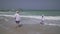 Girl teenager with dad go into the sea waves of Persian Gulf on the beach of Dubai stock footage video