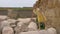 Girl teenager doing acrobatic exercise on large stone. Girl making gymnastic