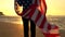 Girl teenager female young woman holding an American US Stars and Stripes flag on a beach at sunset or sunrise