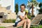 Girl teenager with green apple, resting sitting on sun lounger in garden