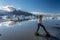 Girl teenager jumping over rocks in the border of Fjallsarlon glacier lake. Southern Iceland