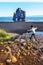 Girl teenager is jumping over water stream in the border of Hindisvik bay in Northwest Iceland, the Hvitserkur basalt stack is at