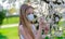 Girl teenager in protective medical mask in the spring among blooming garden. Quarantine coronavirus in Europe. Allergy to
