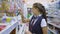 Girl teenager in school uniform at the supermarket, buys a pencil for school.