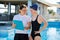 Girl teenager swimmer in sports swimsuit cap with woman trainer near outdoor pool