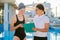 Girl teenager swimmer in sports swimsuit cap with woman trainer near outdoor pool