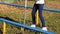 Girl teenager walking on narrow crossbar with pole while obstacle course in park