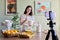 Girl teenager young food blogger cooking orange pancakes, pours milk