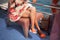 A girl with temporary henna tattoos on her legs. Sits in colorful dress on a chair on a cruise ship