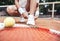 Girl on tennis court in the sport club. Cropped image of a little tennis player. Girl child tying shoelaces on tennis court.