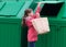 Girl throws out a paper bag opening the trash container