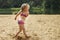 Girl throws sand. Beautiful girl playing with sand on beach. child having fun. vacation happiness and freedom concept