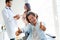 Girl with thumbs up while the doctor talks to her mother in the office.