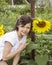 Girl in the to grow a sunflower. Happy smile on her face