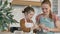 Girl touches mommy nose by finger with flour in kitchen