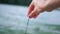 The girl touches the sand on the river with her fingers. Close-up shot of a woman\\\'s hand on a background of sand