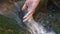 Girl touches water in a clean river with her hand