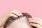 Girl touching her hair close-up on pink background, hair loss concept.
