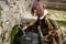 Girl touching water from a natural fountain